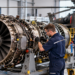 Technician maintaining a helicopter turboshaft engine in a modern aircraft maintenance facility