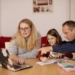 A woman and a man helping a child with schoolwork on a laptop