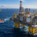 AI-generated contextual illustration of a generic offshore oil and gas platform with support vessel in the North Sea; not the Atlas CO₂ storage facility or infrastructure built for the project