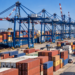 Editorial illustration of a Polish container terminal with shipping containers, cargo vessel and port cranes
